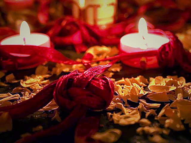 Velas atadas con cinta roja para ritual de unión y pasión de pareja
